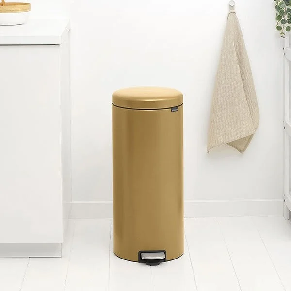 a gold trash can in a kitchen